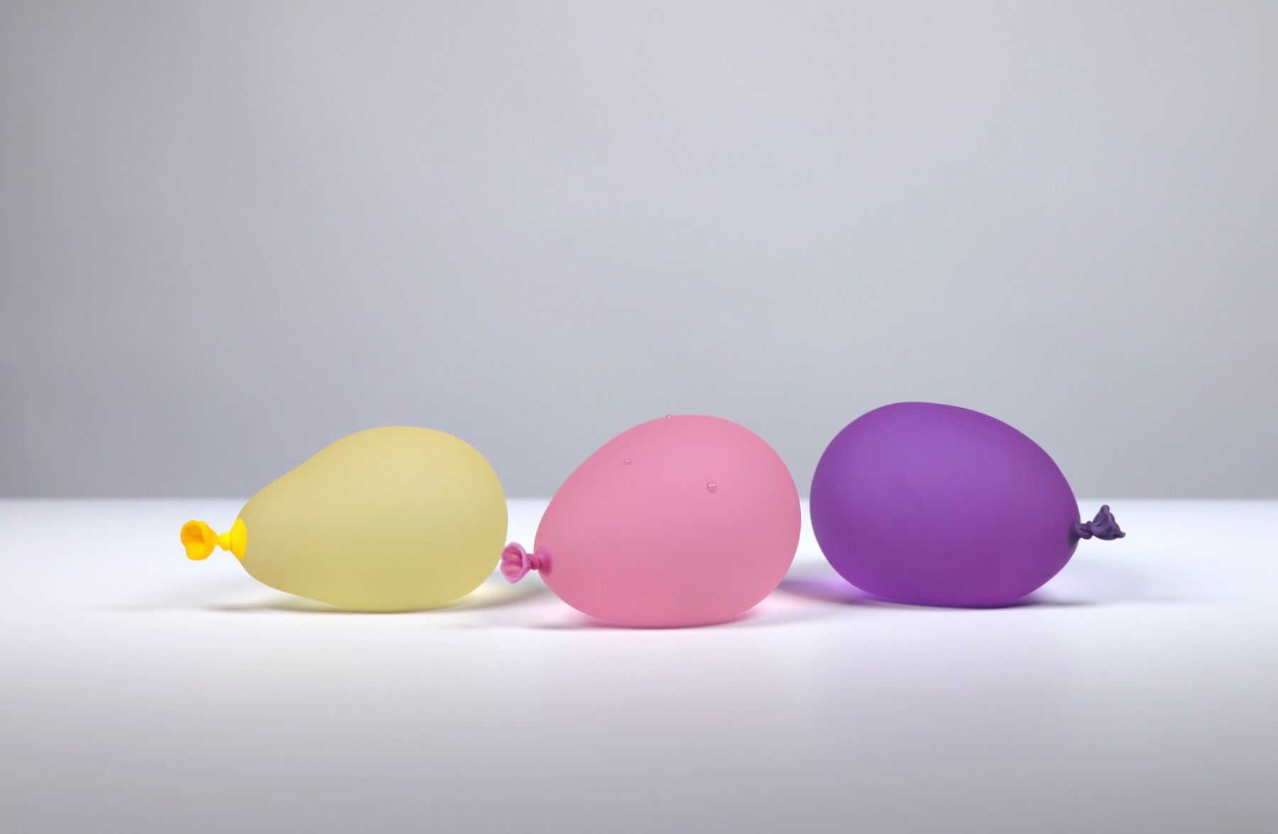 Dylan Martinez - Water Balloon Trio 4 - Pink w/ droplets, Yellow, Dark Purple, 2026, Glass Sculptures - Hot Sculpted, Sand...